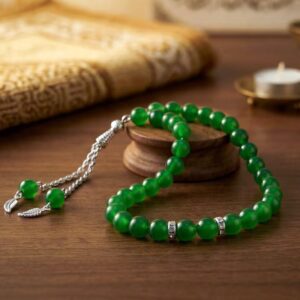 Parrot green tasbeeh placed on prayer mat Islamic setting
