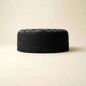 Side profile of black white Muslim namaz cap showing structured hard material