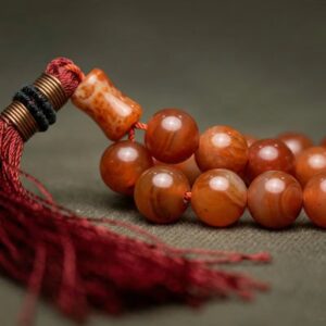 Close up of red Aqeeq stone tasbeeh natural polished beads